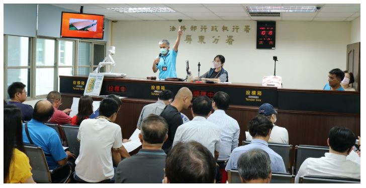 主持倉庫拍賣的書記官（左一）把 7 張桌子銷售一空