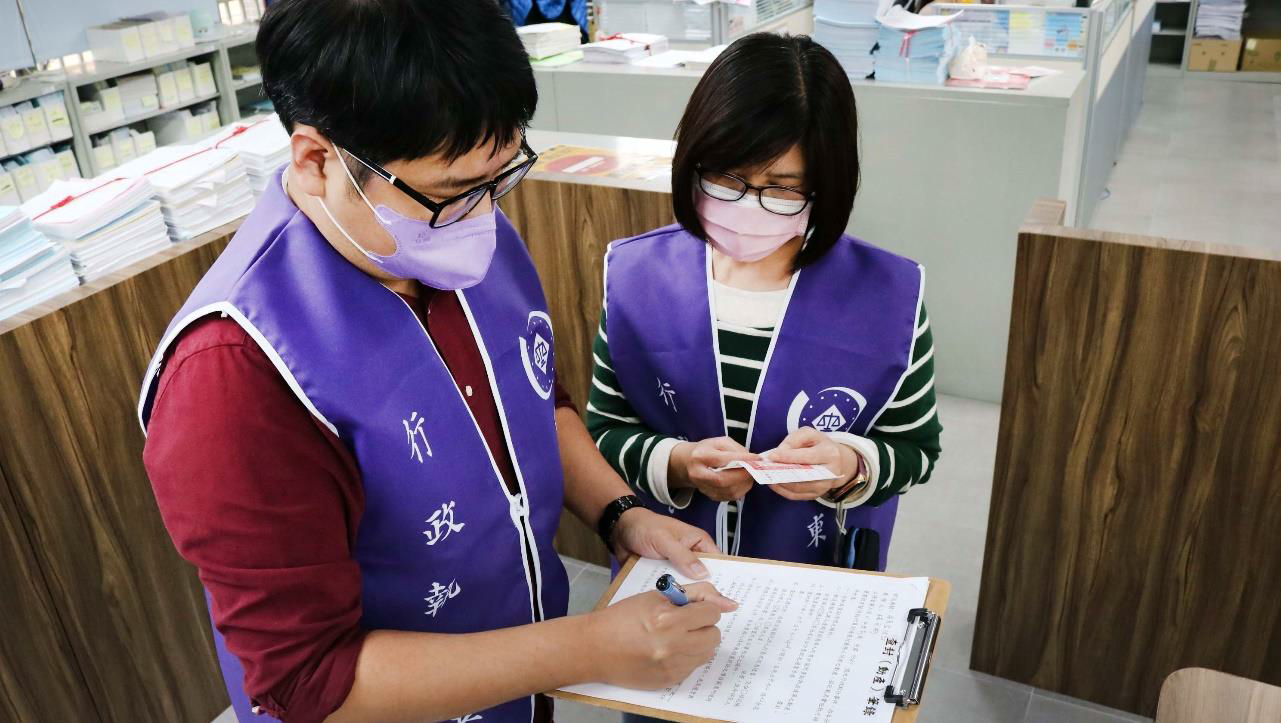 書記官製作查封筆錄，執行員手上拿著封條正要張貼，準備進行貨車查封程序。